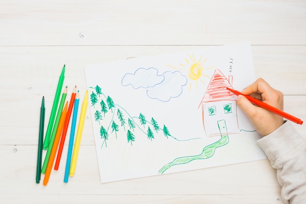 Menselijke hand die een hand getrokken tekening met rode viltstift schilderen