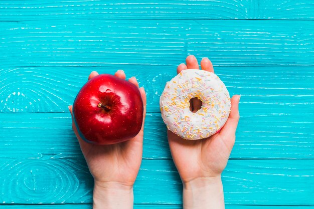 Menselijke hand met appel en donut