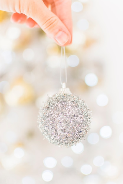 Gratis foto menselijke hand met speelgoed bauble