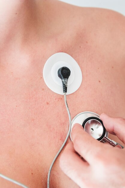 Menselijke hand met stethoscoop die ademhaling van persoon controleert