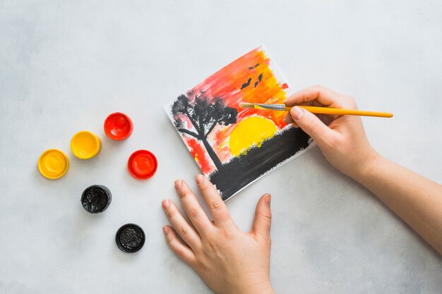 Menselijke hand schilderij prachtige landschap gezien op papier