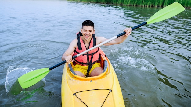 Mensen bespattend water met peddel terwijl het kayaking op meer