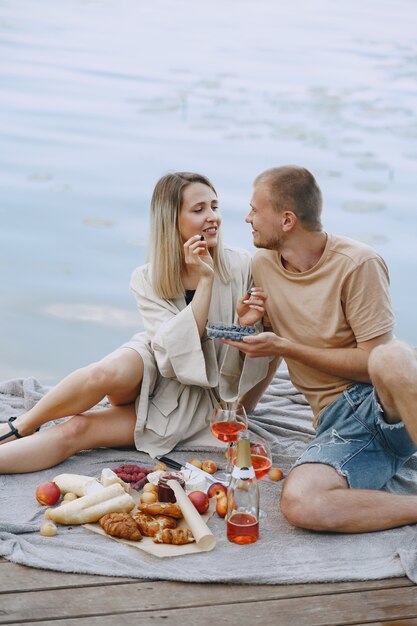 Mensen bij de rivier. Heerlijke gezonde zomerpicknick op het gras. Vruchten op een blancet.