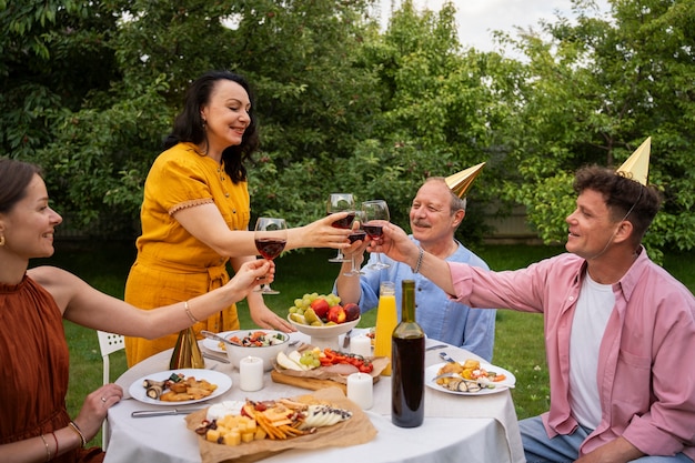 Gratis foto mensen buiten in de tuin vieren een oudere verjaardagsfeestje