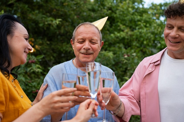 Gratis foto mensen buiten in de tuin vieren een oudere verjaardagsfeestje