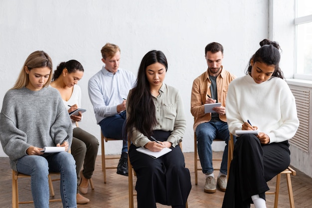 Mensen die aantekeningen maken tijdens een groepstherapiesessie