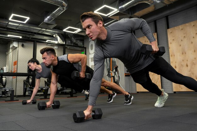 Mensen die binnen samen met dumbbells werken