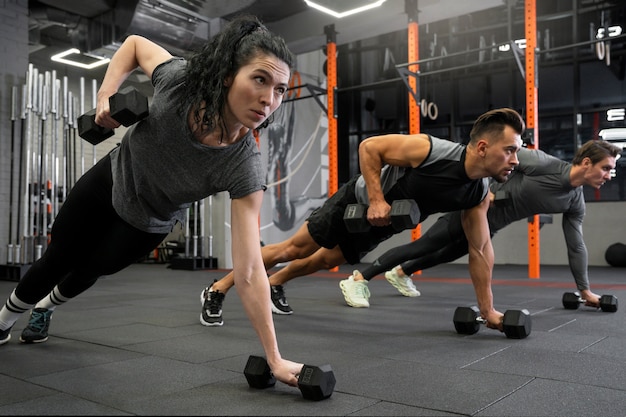 Gratis foto mensen die binnen trainen met dumbbells