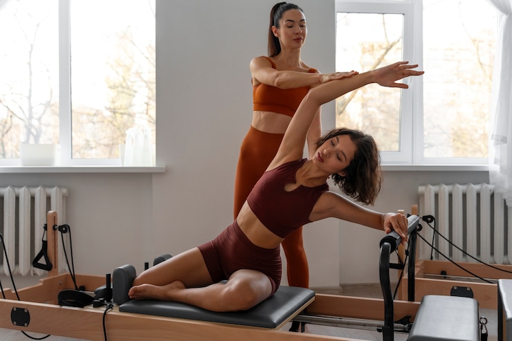 Gratis Foto mensen die een pilates-reformerles volgen