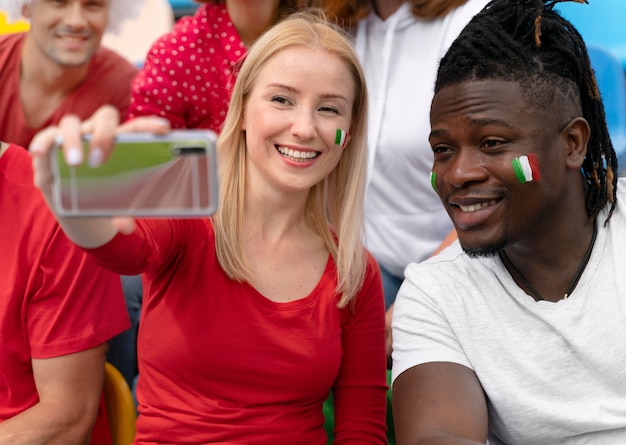 Gratis foto mensen die een selfie maken bij een voetbalwedstrijd