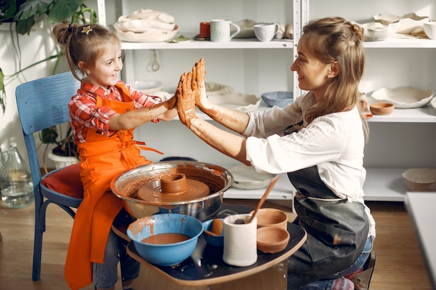 Mensen die een vaze maken van een klei op een pottenbakkersmachine