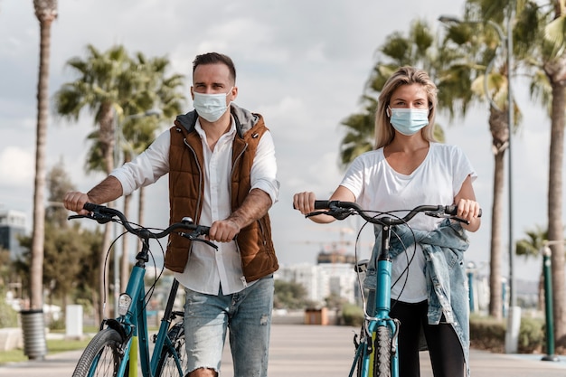 Gratis foto mensen die fietsen terwijl ze een medisch masker dragen
