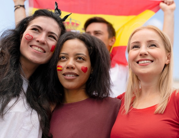 Mensen die op een zonnige dag naar een voetbalwedstrijd kijken