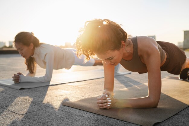 Mensen die samen trainen bij zonsondergang buitenshuis