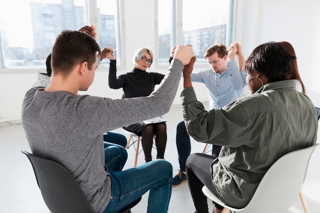 Mensen die zich met gesloten ogen bevinden en handen opheffen