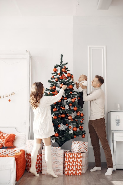 Mensen die zich voorbereiden op Kerstmis. Mensen bij de kerstboom. Familie rust in een feestelijke kamer.