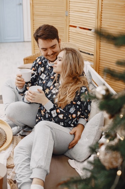 Mensen in een kerstversiering. Man en vrouw in een identieke pyjama. Familie op een bed.