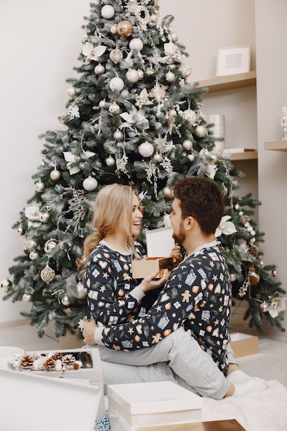 Mensen in een kerstversiering. Man en vrouw in een identieke pyjama. Familie thuis.