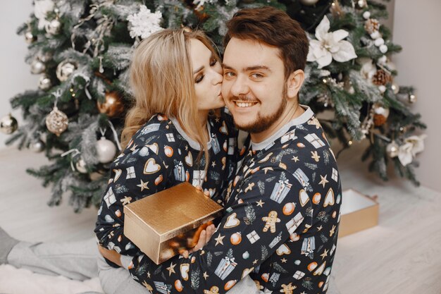 Mensen in een kerstversiering. Man en vrouw in een identieke pyjama. Familie thuis.