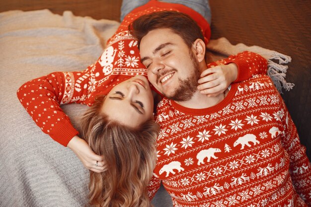 Mensen in een kerstversiering. Man en vrouw in een rode trui.