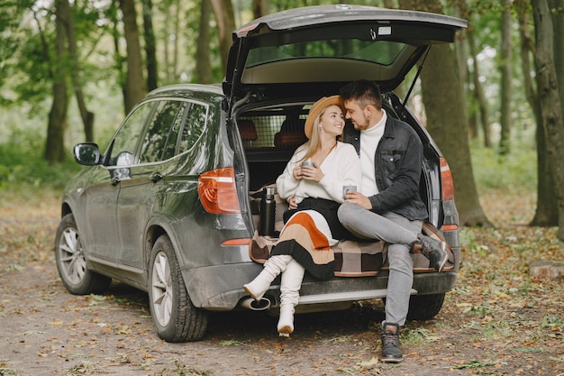 Mensen in een park. Vrouw in een witte trui. Mensen in een kofferbak.