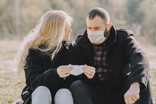 Mensen in maskers zitten in een bos