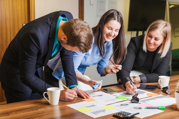 Mensen leunend op bureau staan ​​lachend