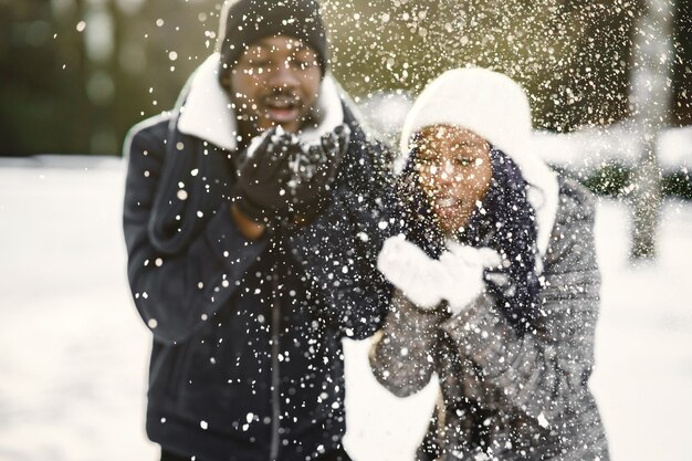 Mensen lopen naar buiten. Winter dag. Afrikaans echtpaar