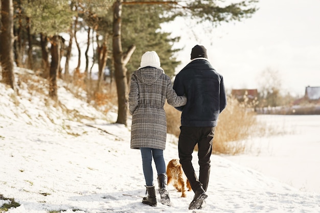 Mensen lopen naar buiten. Winter dag. Afrikaanse echtpaar met hond.