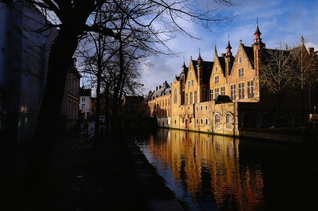 Mensen lopen op de stoep in de buurt van een gracht in het midden van gebouwen