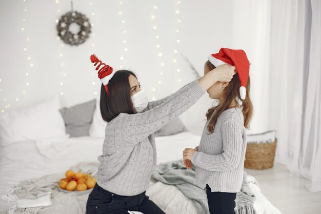 Mensen maken zich klaar voor Kerstmis. Coronavirus-thema. Moeder speelt met haar dochter. Kind in een grijze sweater.