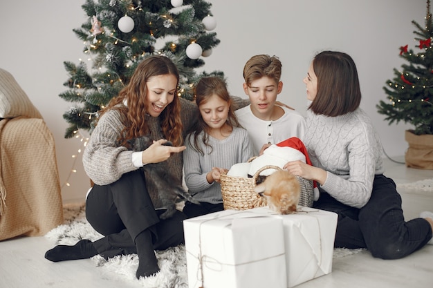 Mensen maken zich klaar voor Kerstmis. Mensen die bij de kerstboom zitten.