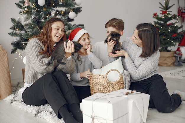 Mensen maken zich klaar voor Kerstmis. Mensen die bij de kerstboom zitten.