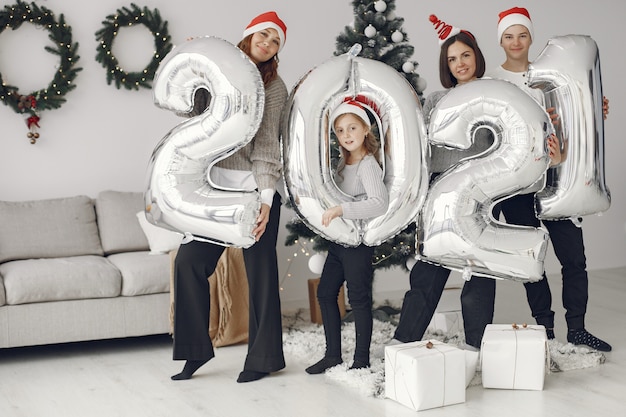 Mensen maken zich klaar voor Kerstmis. Mensen met ballons 2021 / Familie rust uit in een feestelijke kamer.