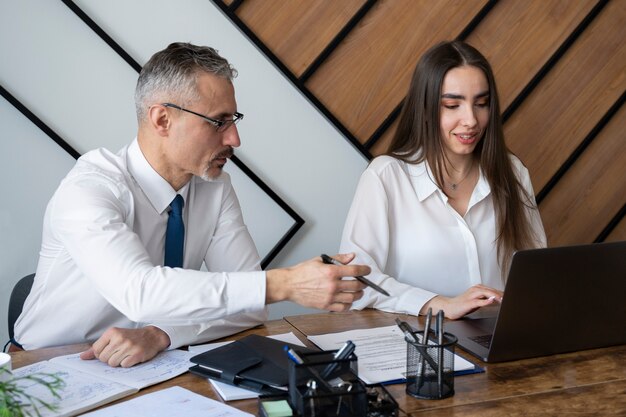 Mensen met een gemiddeld shot aan een bureau