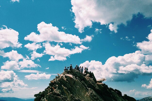 Mensen op de top van de berg boven de blauwe lucht