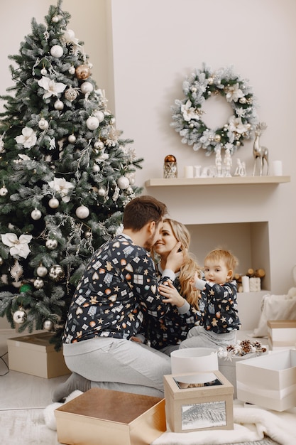 Mensen repareren voor Kerstmis. Mensen spelen met kind. Familie rust in een feestelijke kamer.