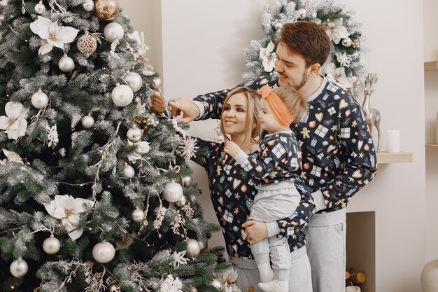 Mensen repareren voor Kerstmis. Mensen spelen met kind. Familie rust in een feestelijke kamer.