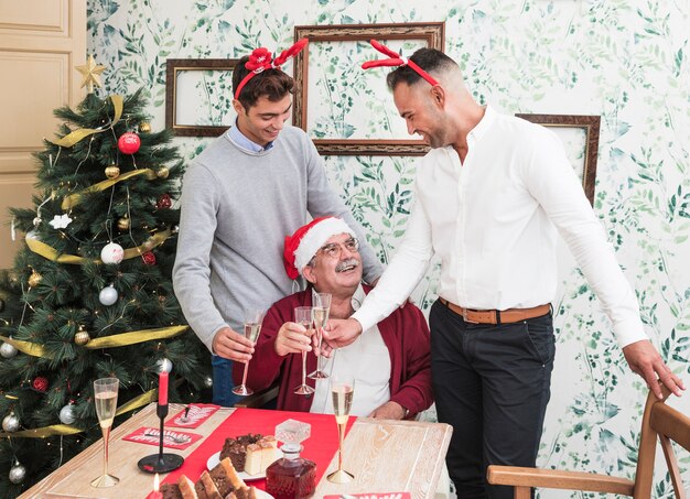 Mensen rinkelen glazen champagne in de buurt van feestelijke tafel