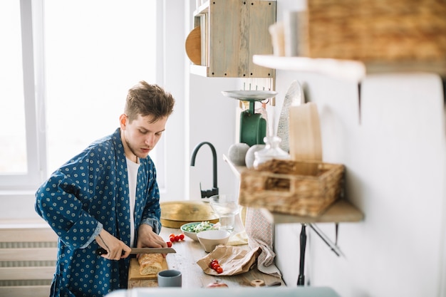 Mensen scherp brood op houten hakbord met mes in keuken