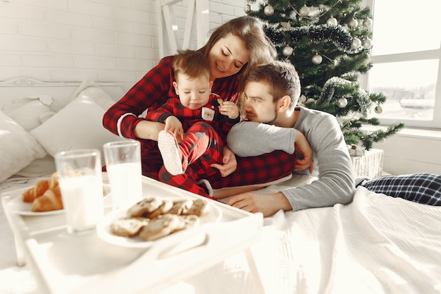 Mensen thuis. familie in een pyjama. melk en croissants op een dienblad.