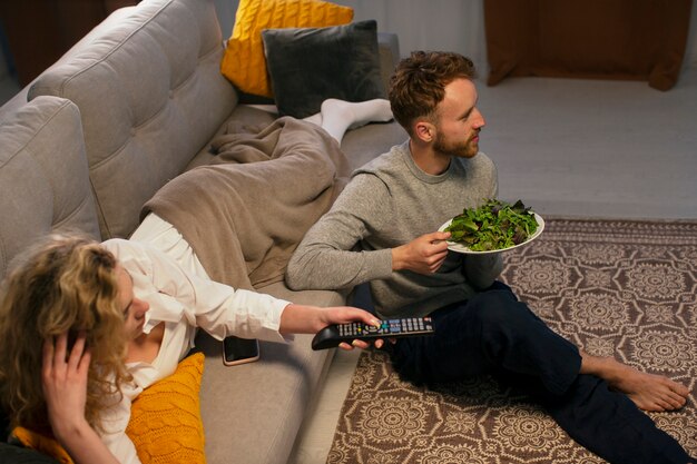 Mensen uit een hoge hoek die eten en tv kijken