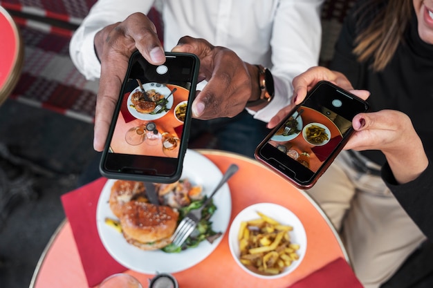 Gratis foto mensen uit een hoge hoek die voedselfoto's maken