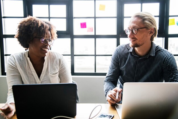 Mensen uit het bedrijfsleven werken op laptops tijdens een vergadering