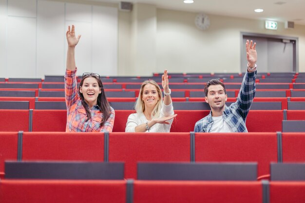 Mensen verhogen handen op seminar