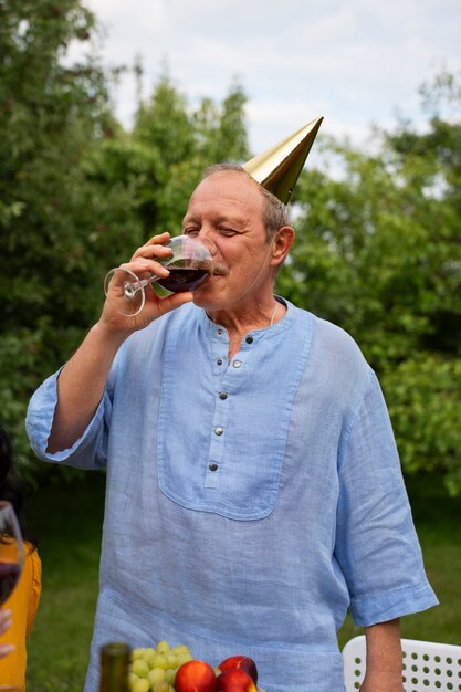 Mensen vieren een oudere verjaardagsfeestje buiten in de tuin