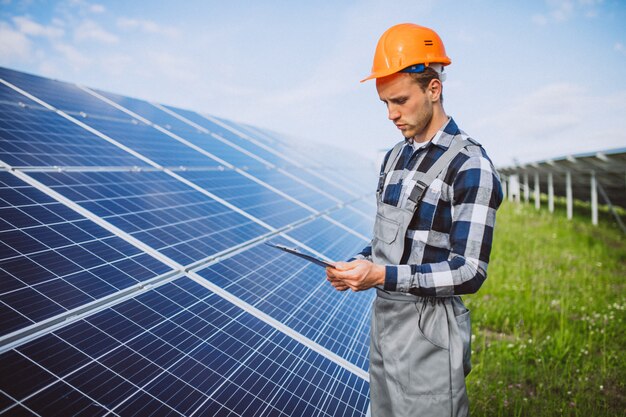 Mensenarbeider in firld door de zonnepanelen