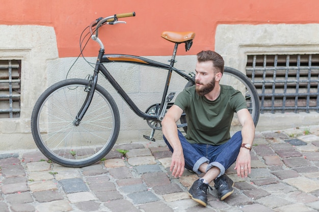 Gratis foto mensenzitting op steenbestrating voor fiets