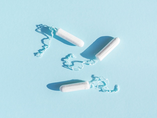 Menstruele tampons met draad op blauwe achtergrond