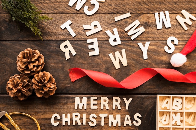Gratis foto merry christmas inscriptie in de buurt van haken en ogen, letters en lint